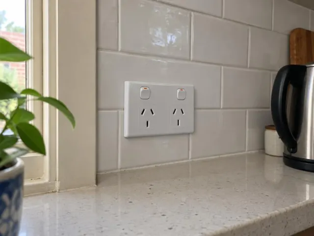 White double power point on a tiled kitchen splashback above a stone benchtop in Double Bay